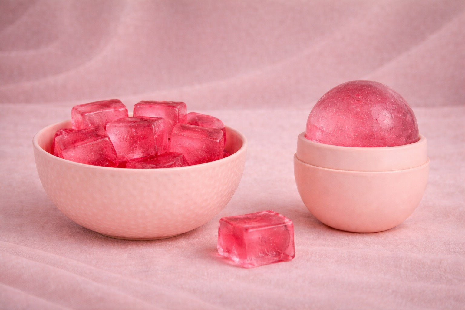 Glaçons carrés rose rouge à l’hibiscus dans un bol en céramique rose pâle, accompagnés d’un ice roller rose, rituel beauté naturel pour réveiller l’éclat de la peau, ambiance féminine et premium.