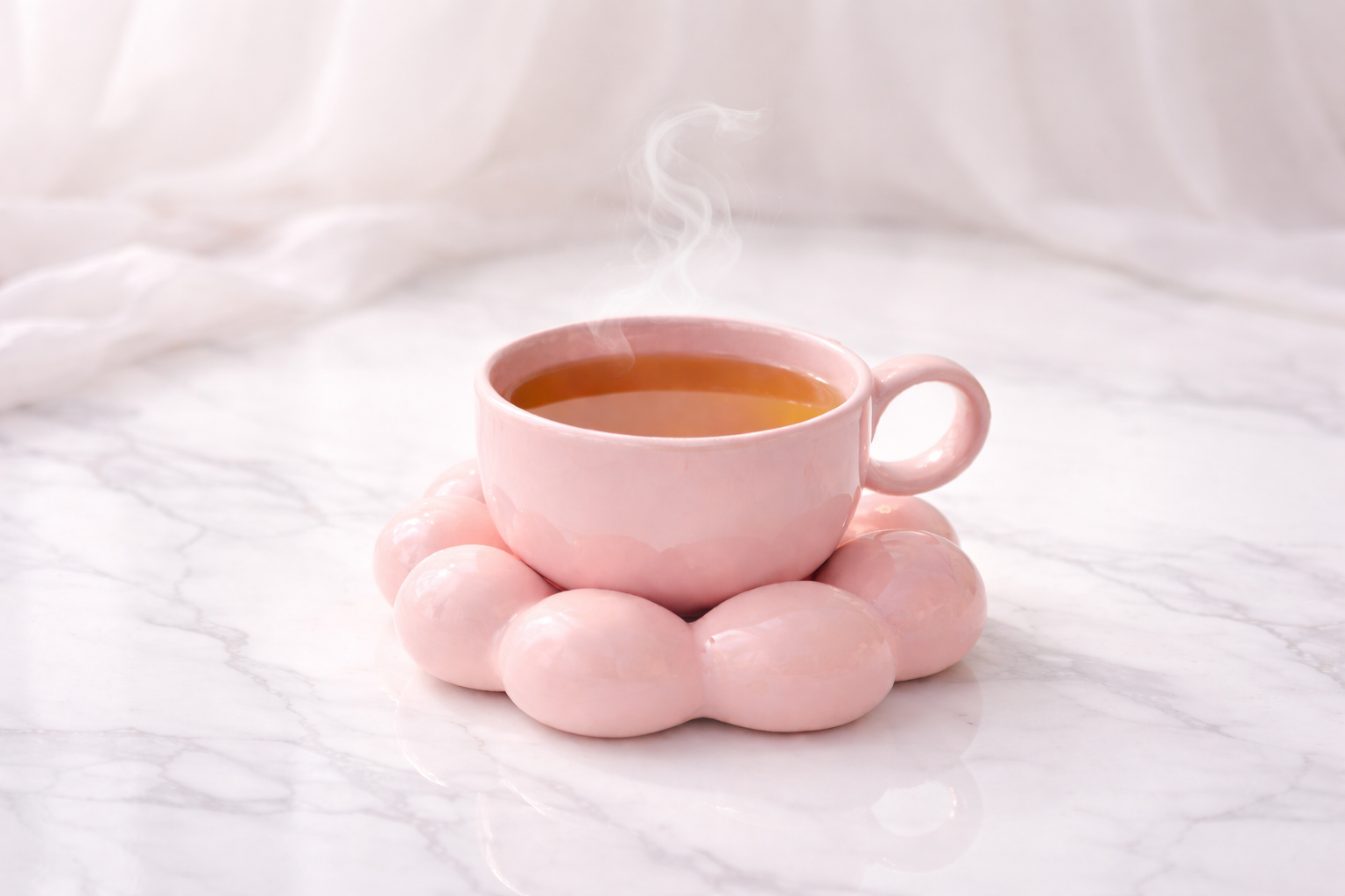 Infusion Pink Élixir aux notes fruitées servie dans un mug en verre double paroi avec fleurs roses, ambiance beige poudré élégante.