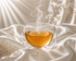 Infusion Deep Silk Hazellia dans un mug en verre double paroi, infusion naturelle ambrée sur un satin ivoire, rituel bien-être inspiré de l’élégance scandinave.


