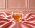 Infusion Marquise Absolu Hazellia dans un mug en verre double paroi sur satin rose poudré, univers parisien chic et premium

